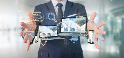 Poster - Businessman holding a Devices connected to a cloud multimedia network 3d rendering