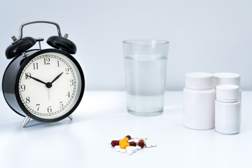 Alarm clock tablet capsules and a glass of water