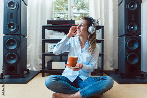 Fotografía Woman listening to music from a Hi-Fi stereo at home