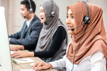 Wall Mural - Beautiful Asian muslim woman working  in call center with team