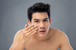 © Atstock Productions - Portrait of shirtless young handsome Asian man checking his face skin