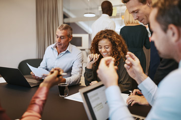 Smiling work colleagues having a meeting in an office boardroom