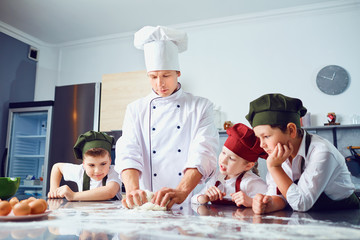 Wall Mural - Children learn to cook in the classroom in the kitchen