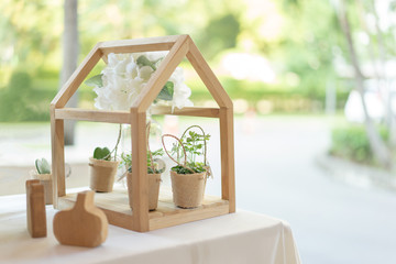 Little flower pot and tree pot in bag with mini wood house for the wedding decoration.