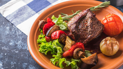 Juicy beef steak with  roast vegetables. Copyspace. Toned photo