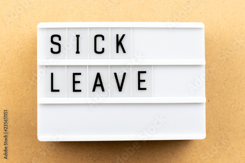 Fotografia Light box with word sick leave on wood background