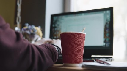 creative work process, woman hands on the keyboard, a hot cup of tea and a slice of orange. Workplace, notebook with pen and laptop, the working. coffee shop, phone, smartphone on the table, study.