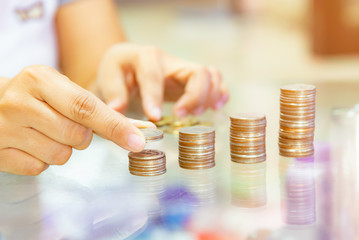 Wall Mural - Saving money. Female hand stack coins.