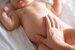 Massage stomach for little newborn baby. Mom massaging colic tummy of newborn. Healthy motherhood.
