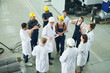 © Seventyfour - High angle view at  multi-ethnic group of workers standing round senior engineer giving instructions on project in workshop