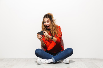 Poster - Portrait of an excited young woman wearing hoodie