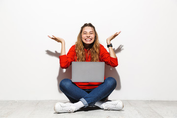 Wall Mural - Portrait of an excited young woman wearing hoodie