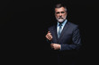 © opolja - Handsome mature business man isolated on black background