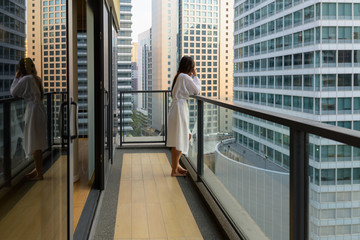 Wall Mural - Young beautiful Asian woman enjoying the view of the city from t