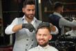 © serhiibobyk - Front view of smiling man getting hairstyle in barbershop