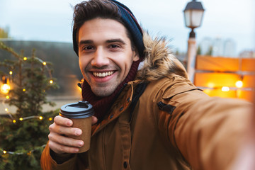 Poster - Happy young man standing posing outdoors winter concept.