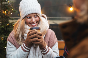 Poster - Happy young friends talking with each other drinking coffee outdoors winter concept.