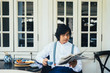 © LUMINA IMAGES - Elegant Asian man sitting on terrace and drinking tea and reading newspapers.