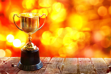 Wall Mural - chamption trophy on wood table with abstract bokeh background, have space for idea.
