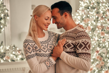 Poster - The happy man and woman standing on the christmas tree background