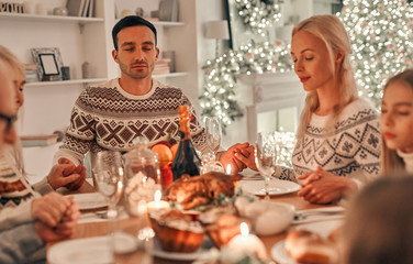 Wall Mural - The family praying at the christmas table