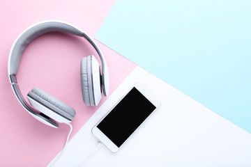 Smartphone with headphones on colorful background