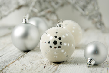 Wall Mural - Christmas white background with silver decorative balls or baubles on rustic wooden background.