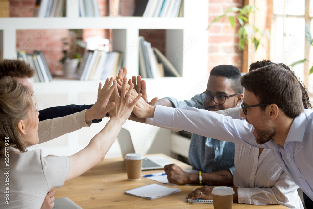 Excited happy multiracial team giving high five, celebrating good ...