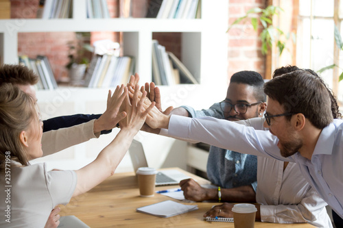 Fotografía Excited happy multiracial team giving high five, celebrating good results, congr