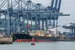 Container cranes loading a ship in port in Panama near the entrance to the Panama Canal.