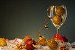 Christmas cards. Wine glass with red and gold Christmas decorations on dark background with copy space.