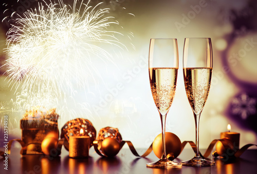 Fotografía two champagne glasses against holiday lights and fireworks - new year celebratio
