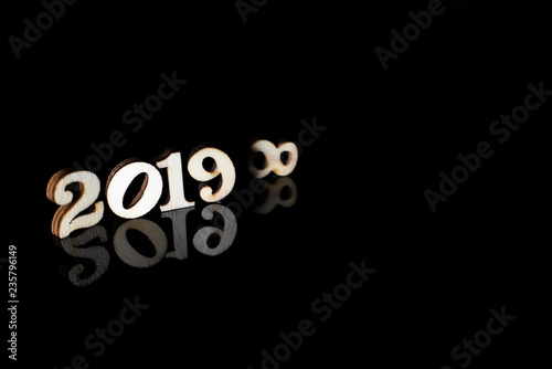 Fotografía New year 2019 with wooden numbers and bright lights on dark background and free space for text