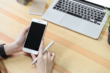 Fototapete - woman holding a blank screen phone and a laptop  and put a smart watch, film effect. Concept technology and modernization.