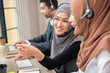 Happy beautiful Asian muslim women working in call center office