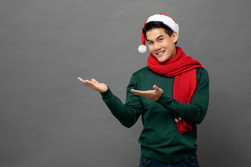 Wall Mural - Studio portrait of Asian man wearing Christmas attire with his arms raised