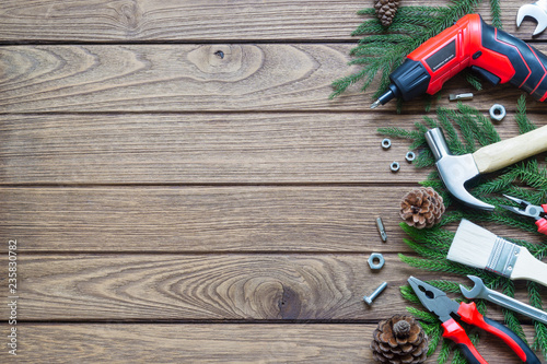 Merry Christmas And Happy New Year Handy Construction Tools Background Concept Hammer Wrenches Screwdriver Pliers Paint Brush Pine Leaves Pine Cones Decoration On Wood Background Buy This Stock Photo And Explore