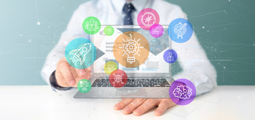 Poster - businessman holding a cloud of colorfull start up icon bubble with a laptop 3d rendering