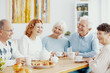 Group of happy older people laughing together on a coffee meeting at nursing home