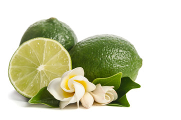 two green limes with half of  juicy lime and beautifull flower isolated on white background