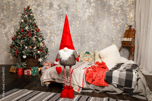 Fotografie, Obraz Christmas gnome near the Christmas tree at home
