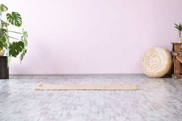 Gym interior with yellow bamboo yoga mat, monstera tropical flower, no people. Copy space