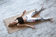 © uv_group - Adult woman meditating in savasana pose on bamboo yoga mat after working out at home and doing yoga exercise. Shavasana Posture, meditation, resting after practice, breathing.