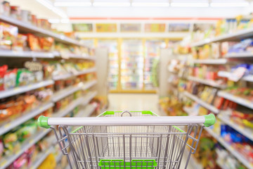 Wall Mural - Shopping cart with Supermarket convenience store aisle shelves interior blur for background