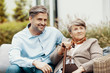 © Photographee.eu - Grey elder lady with walking cane sitting in the garden with her handsome oldest son