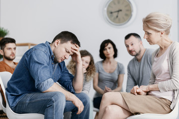 Wall Mural - Man with headache and alcoholism problem and psychotherapist during meeting