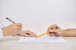 © DragonImages - Crop side view of people signing contract at table sitting in front of each other