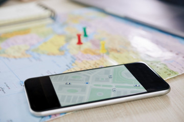 Closeup shot of modern smartphone with GPS application showing map of city 