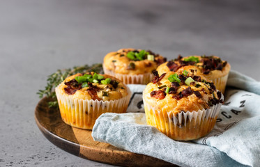 Savory muffins with bacon, quail egg, green onion cheese on a grey stone backdrop. Protein breakfast. Rustic style.