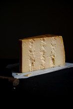 A Block Of Parmesan Cheese On Dark Background